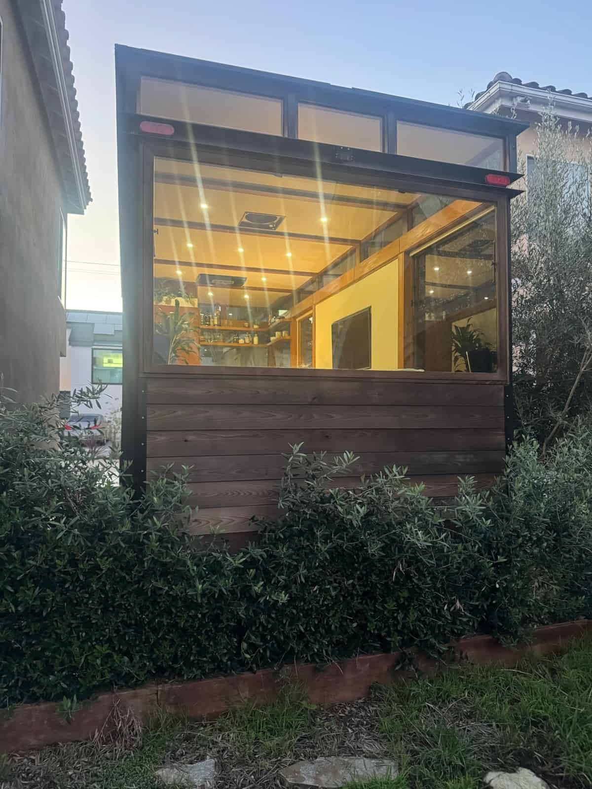 End elevation of the MoD tiny house showing a full-width picture window over cedar siding