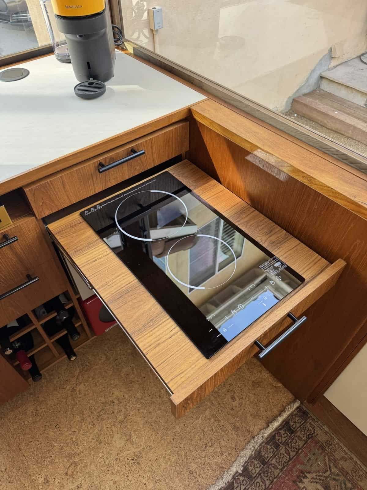 Two-burner induction cooktop mounted in a pull-out teak drawer
