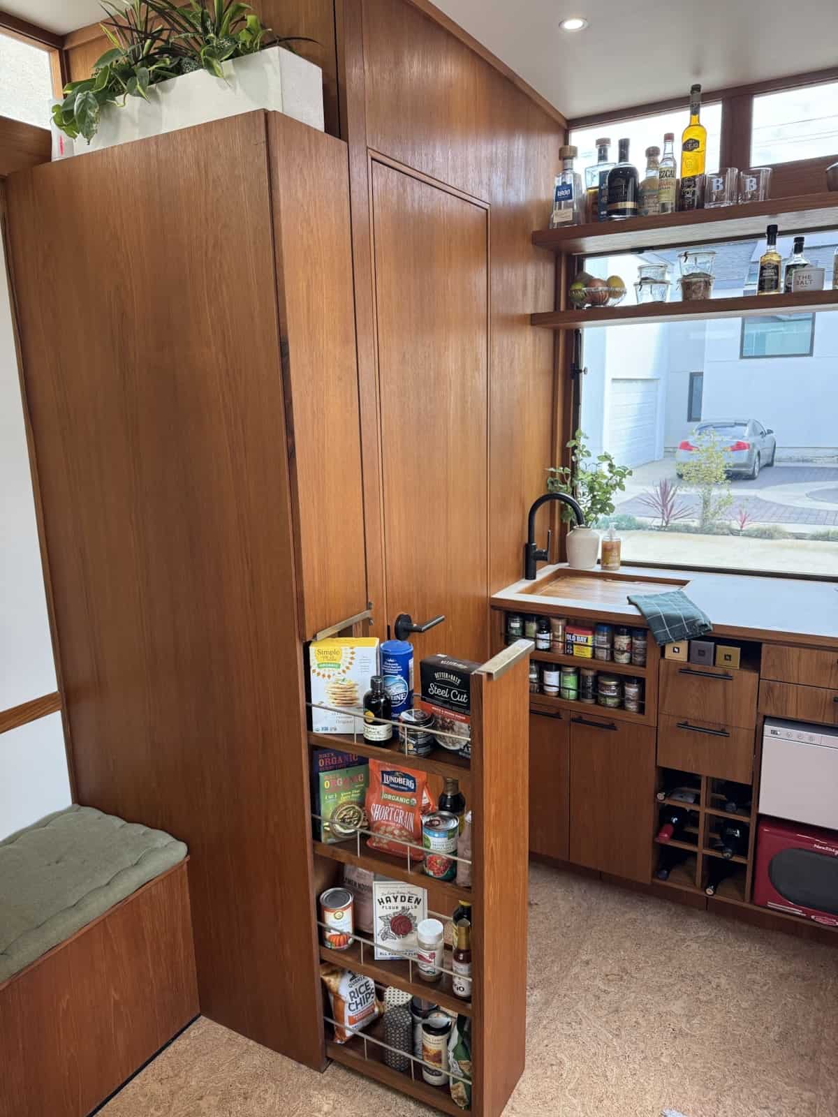 Full-height pull-out pantry beside the kitchenette in the MoD tiny house