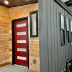 Compact NOAH-Certified tiny house with a red door and black accents.