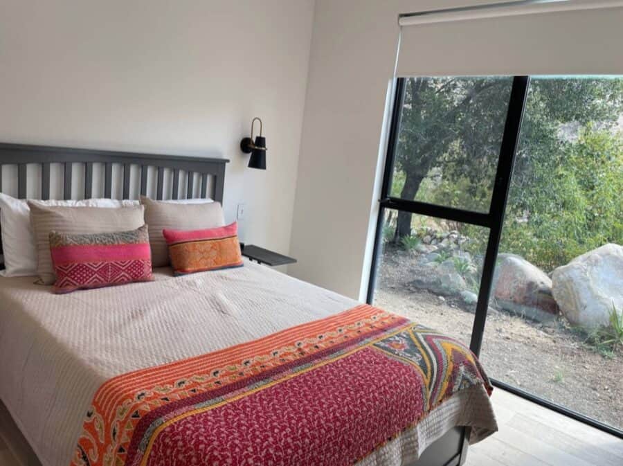 Bright bedroom with large window overlooking nature.