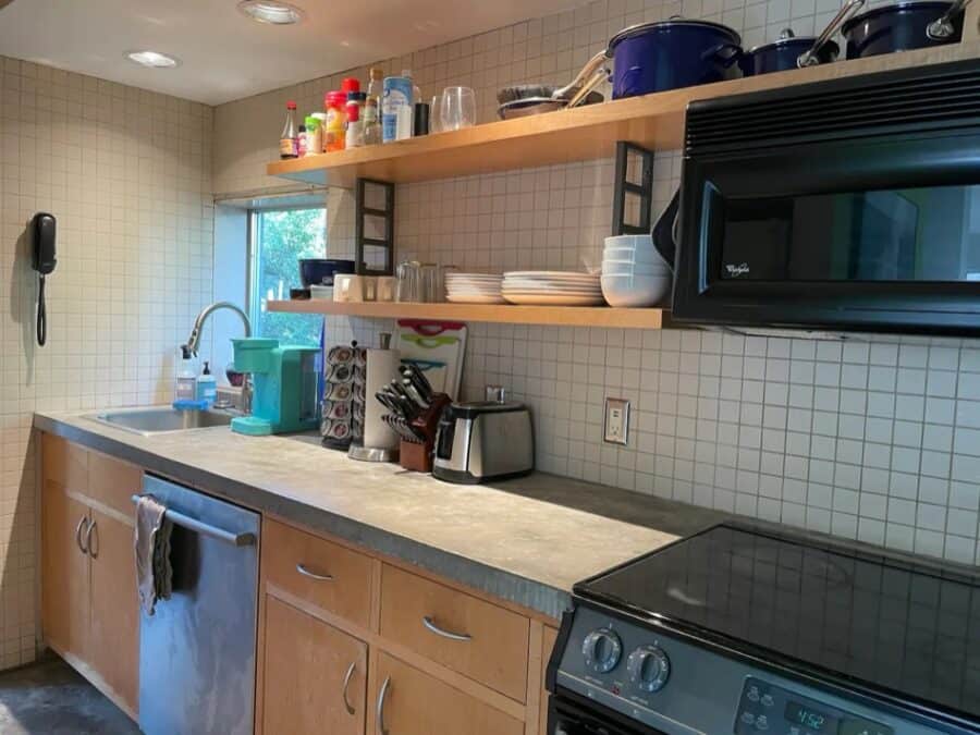 Compact modern kitchen with open shelving and essential appliances.