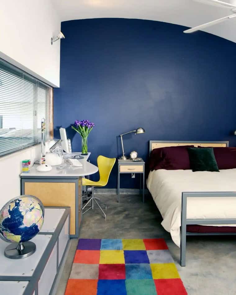 Modern small house bedroom with vibrant decor and functional workspace in Houston, Texas.