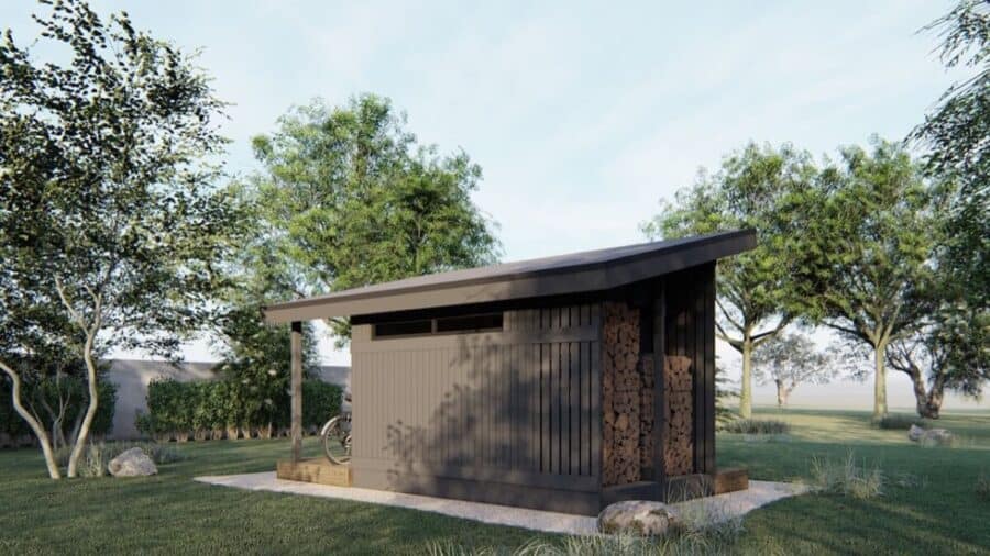 Modern tiny house with sleek black exterior and sloped roof in a lush green setting.