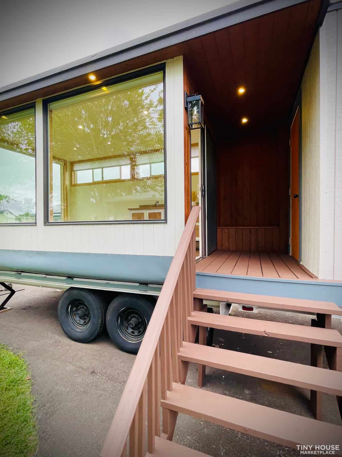 Tiny house on wheels with a sleek exterior and large windows, showcasing innovative small space livi.