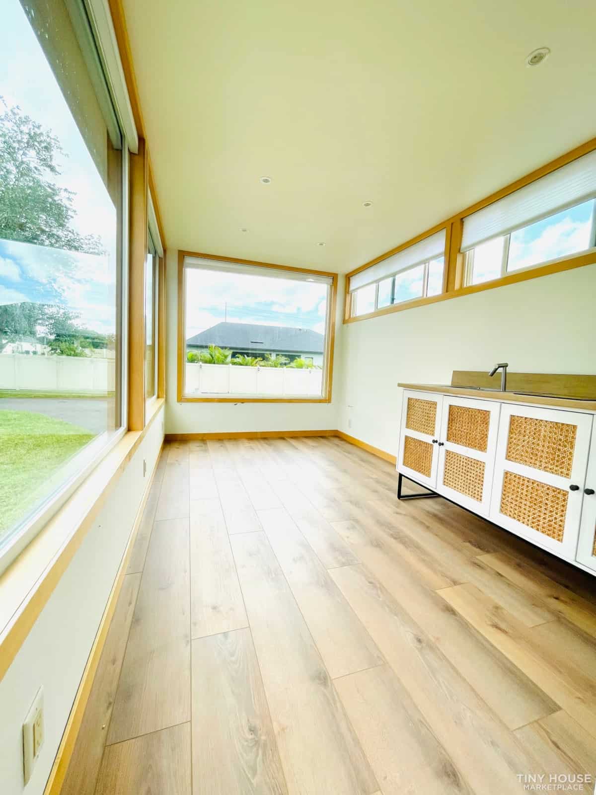 Bright tiny house interior with expansive windows and natural light.