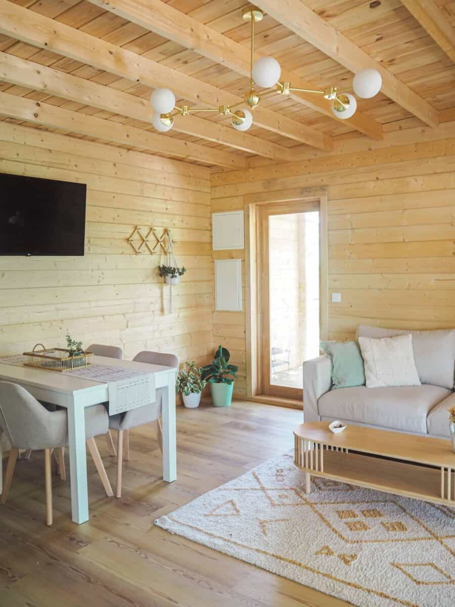 Bright wooden tiny house living space with modern furniture and natural light.