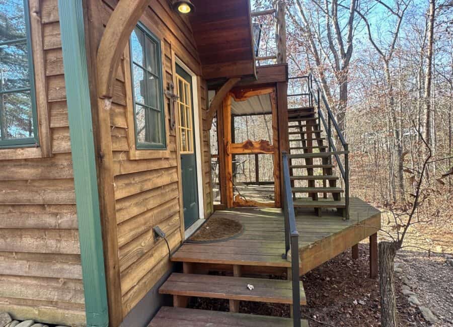 Tiny house with rooftop deck overlooking a peaceful creekside setting.