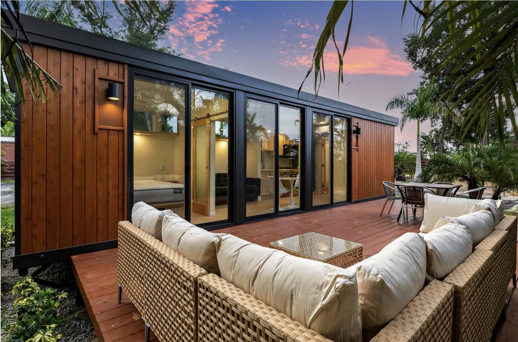 Modern tiny house with outdoor patio and large glass doors.