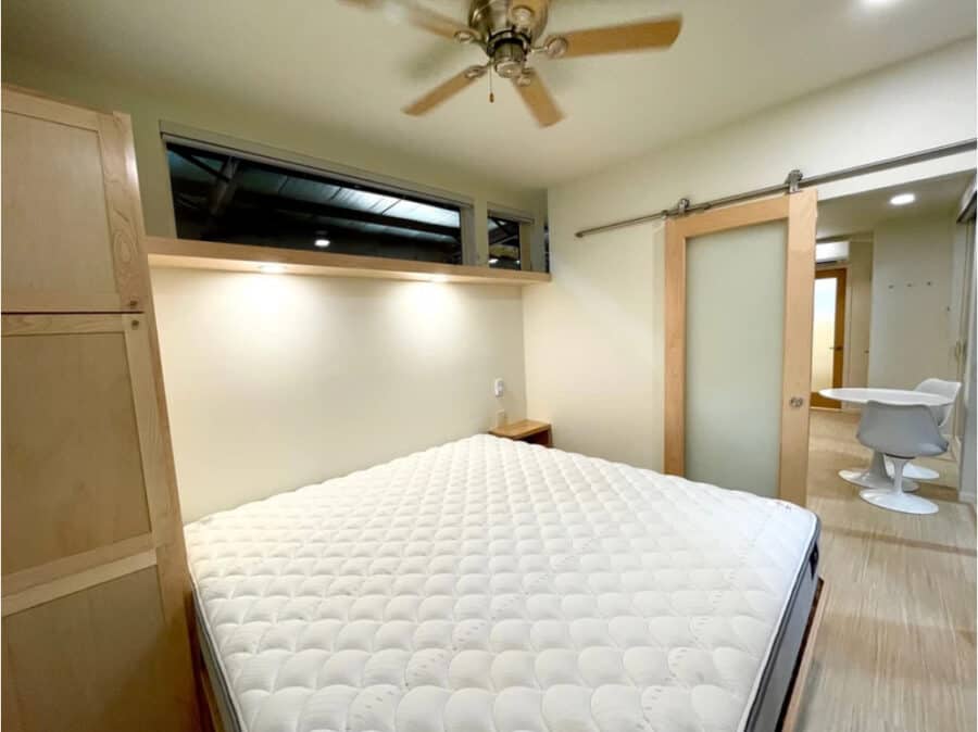 Modern tiny house bedroom with minimalist decor and sliding barn door.
