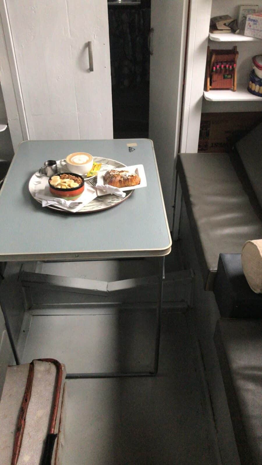 Cozy tiny house interior featuring a small table with snacks and a compact space for relaxation.