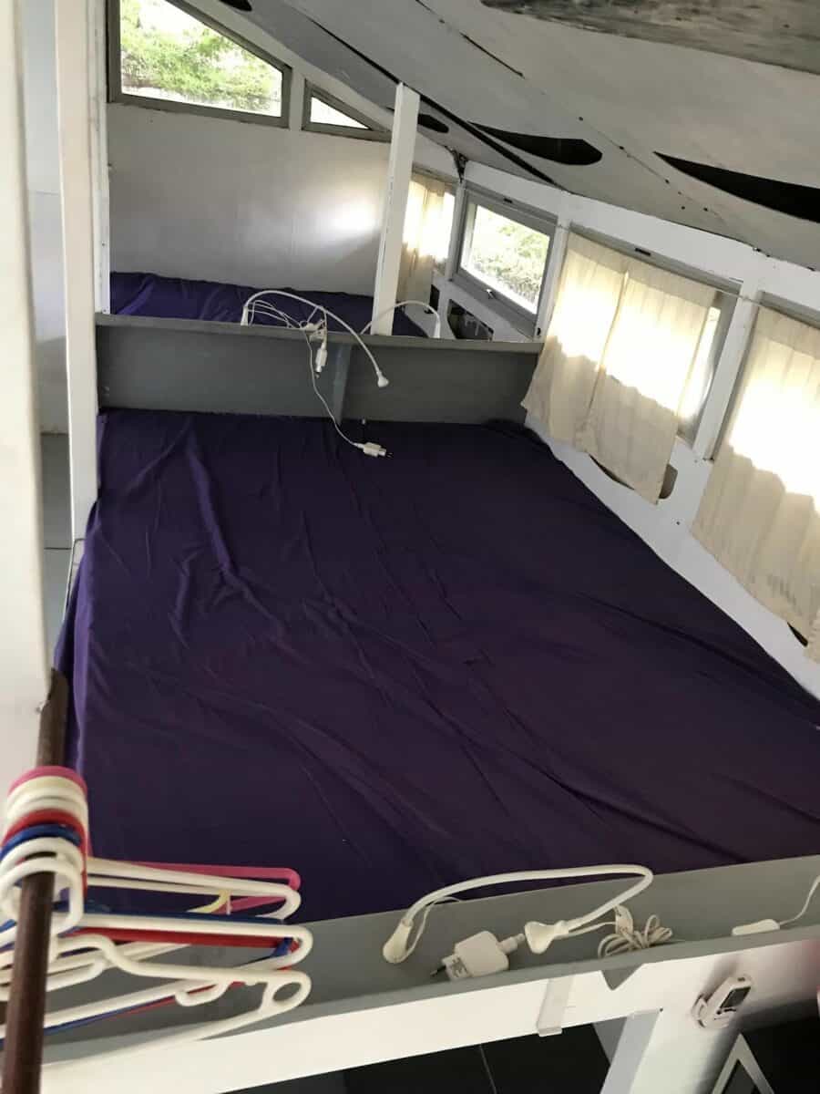 Tiny house interior with a standing loft and large windows for natural light.