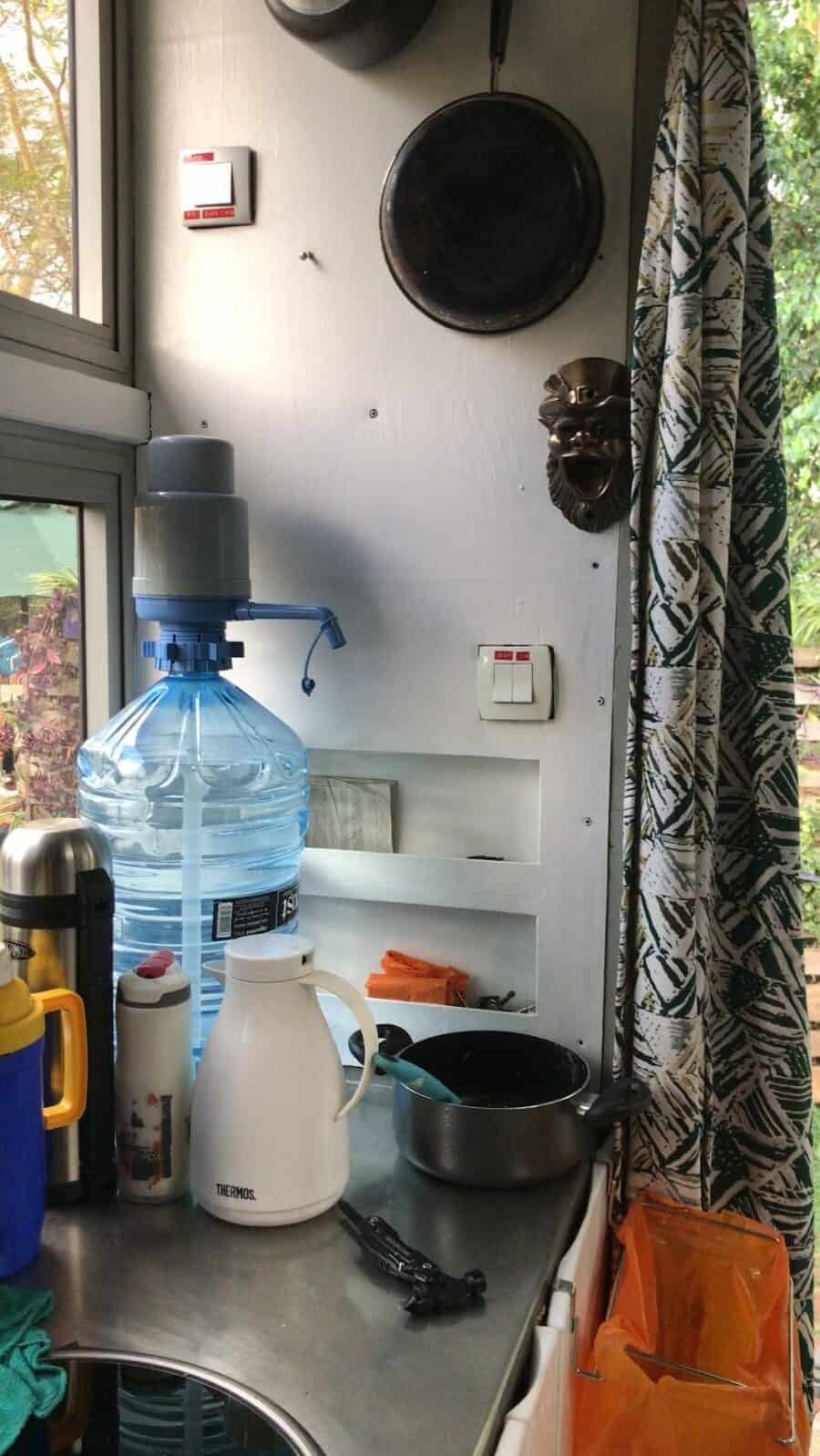 Compact tiny house interior with kitchen essentials and hanging skillet.