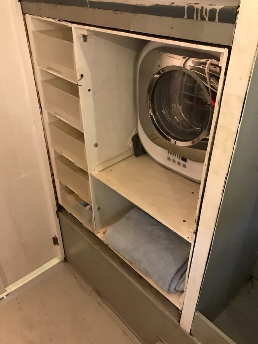 Laundry closet with compact washing machine in tiny house.