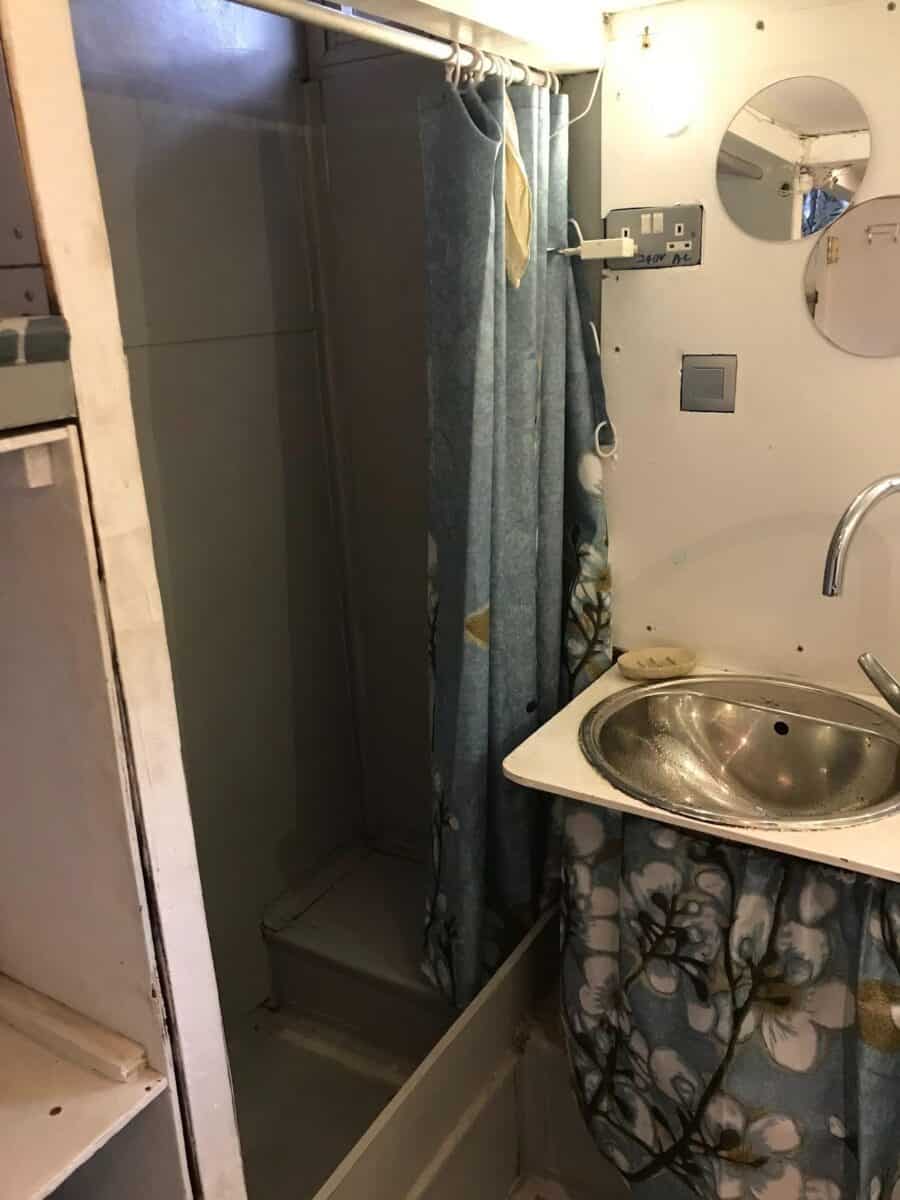 Bathroom in a tiny house with a compact shower and stainless steel sink. Efficient use of space for.