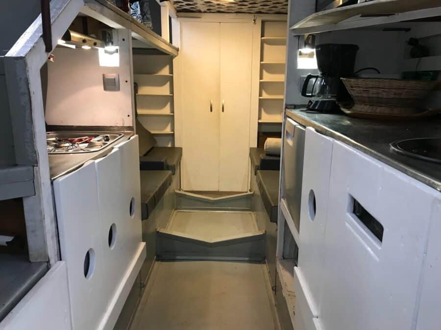 Compact tiny house kitchen with standing loft and efficient storage solutions.