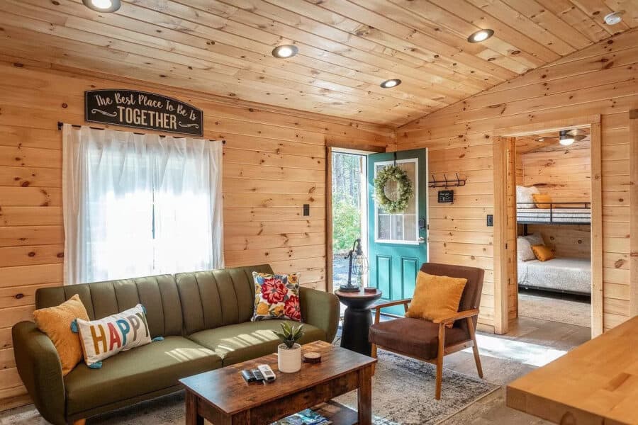 Charming tiny house interior with wooden walls, comfortable seating, and welcoming decor.