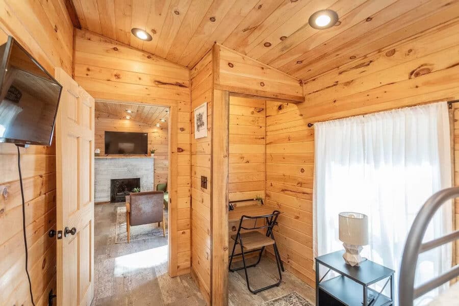 Cozy interior of a 714 sq. ft. cabin with wood paneling, natural light, and simple furnishings in a.