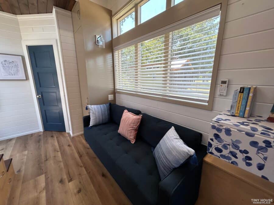 Cozy interior with large windows and comfortable seating in a compact tiny house.