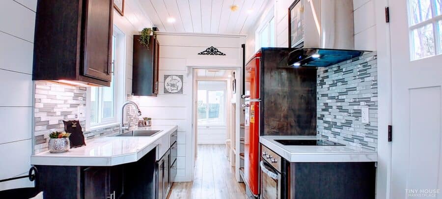 Compact tiny house kitchen with modern appliances and stylish decor.