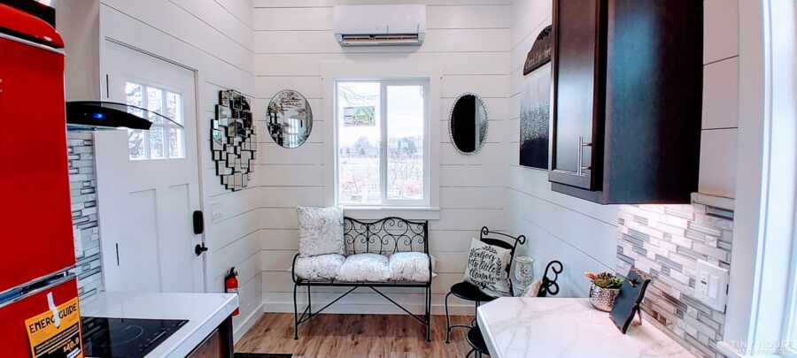 Interior view of a cozy 30 ft. tiny house on wheels with modern decor and efficient space use.