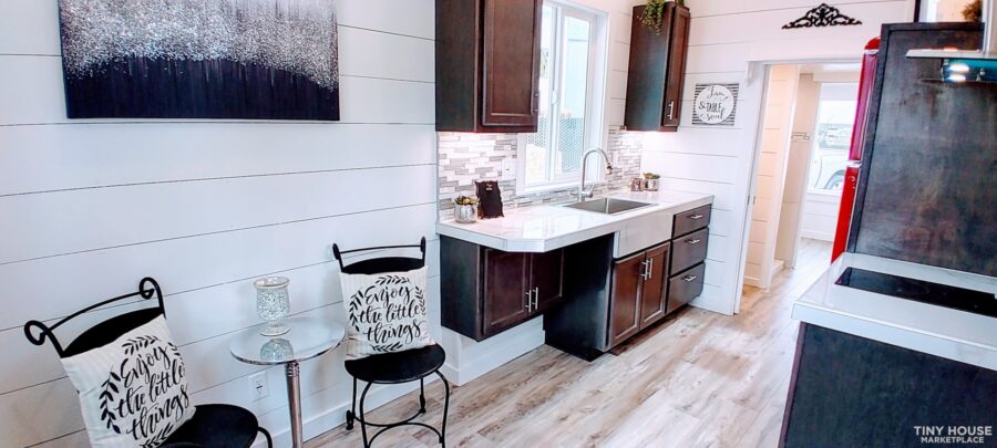 Efficient tiny house kitchen with modern cabinetry and a compact layout on wheels.
