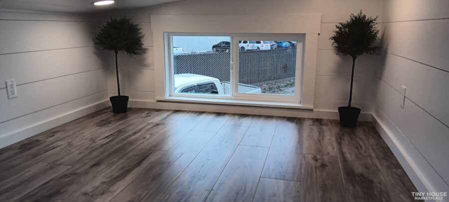 Bright tiny house interior with large window and minimalist decor.