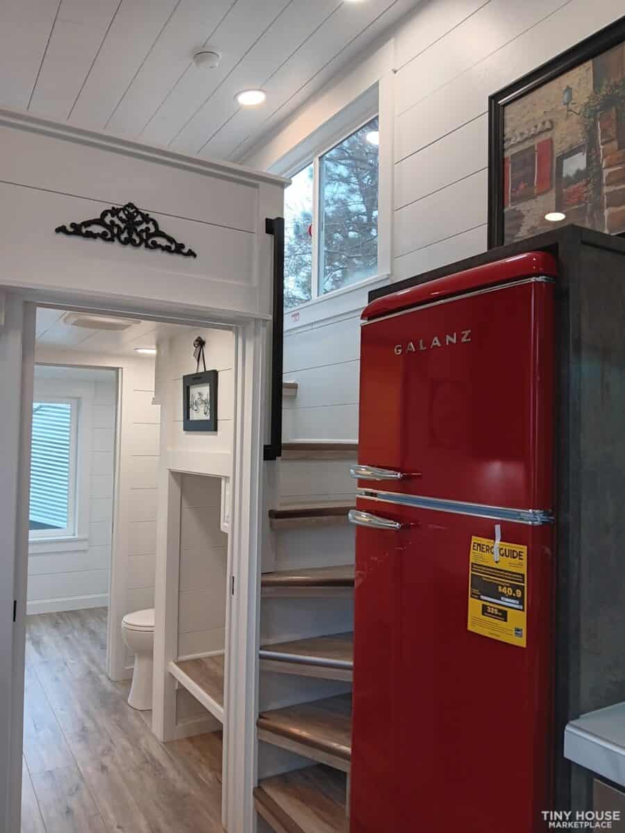 Compact tiny house interior with a red Galanz refrigerator and cozy bathroom space.