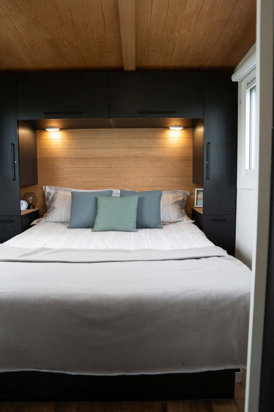 Modern tiny house bedroom with minimalist decor and soft lighting.