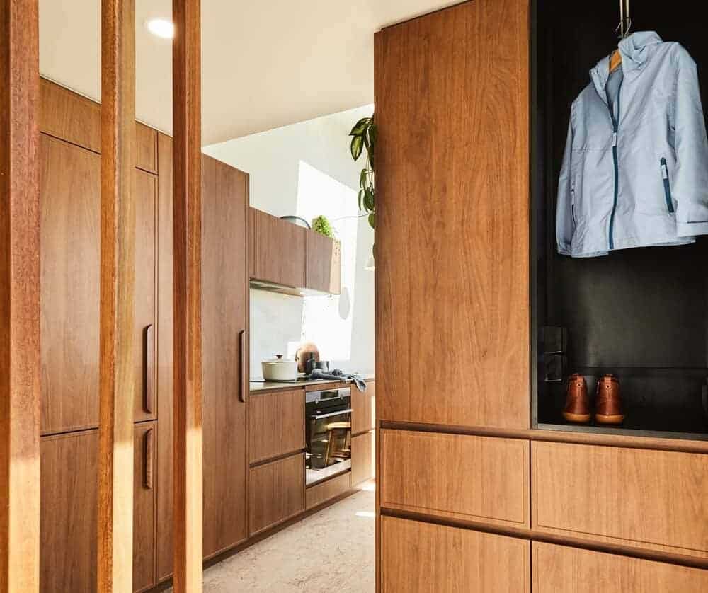 Rich wood cabinetry at the entry and kitchen of the NOOSA tiny house