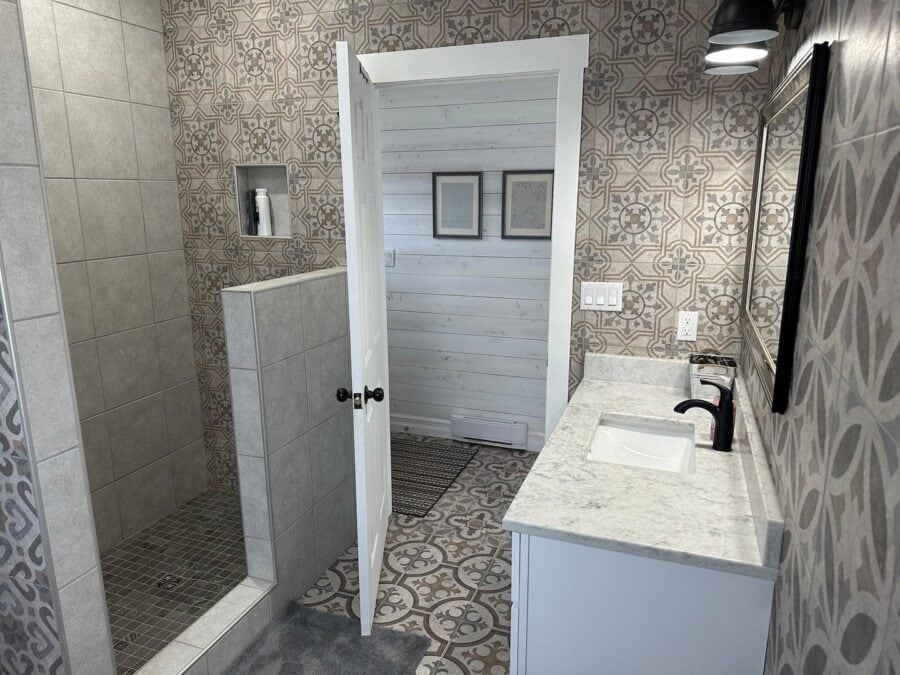 Modern tiny house bathroom featuring patterned tiles and compact design.