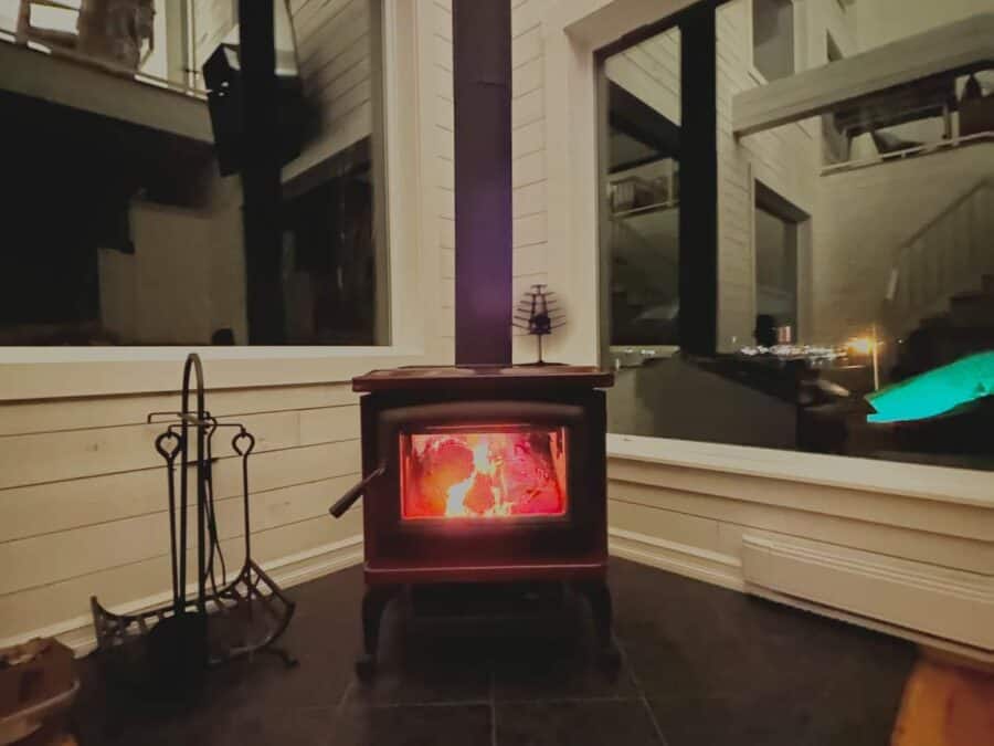 Charming fireplace inside Nora’s Nook cabin with warm glow and rustic decor. Perfect for relaxing sm.