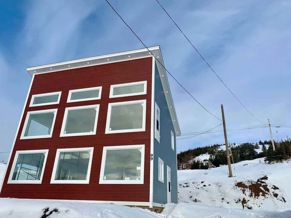 Tiny House with Large Windows in Snowy Landscape