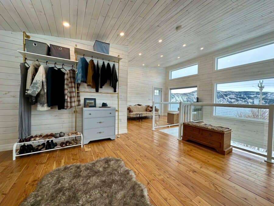 Bright interior of a tiny cabin featuring large windows, wooden floors, and minimalist decor for sma.
