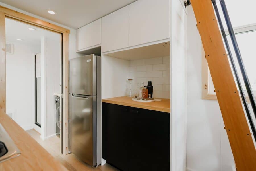 Compact tiny house kitchen with modern appliances and minimalist design.