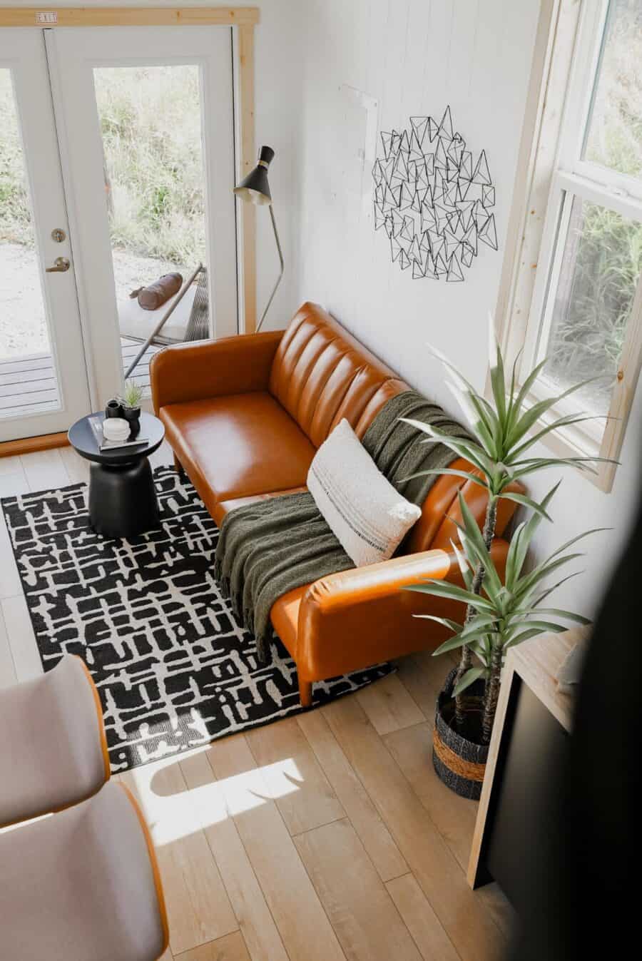 Bright and inviting tiny house interior with a stylish leather sofa and modern decor.