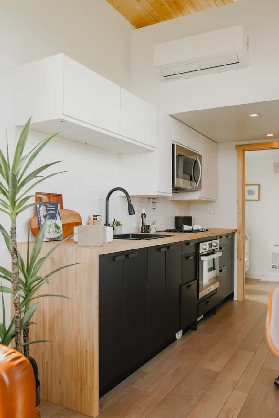 Compact tiny house kitchen with modern appliances.