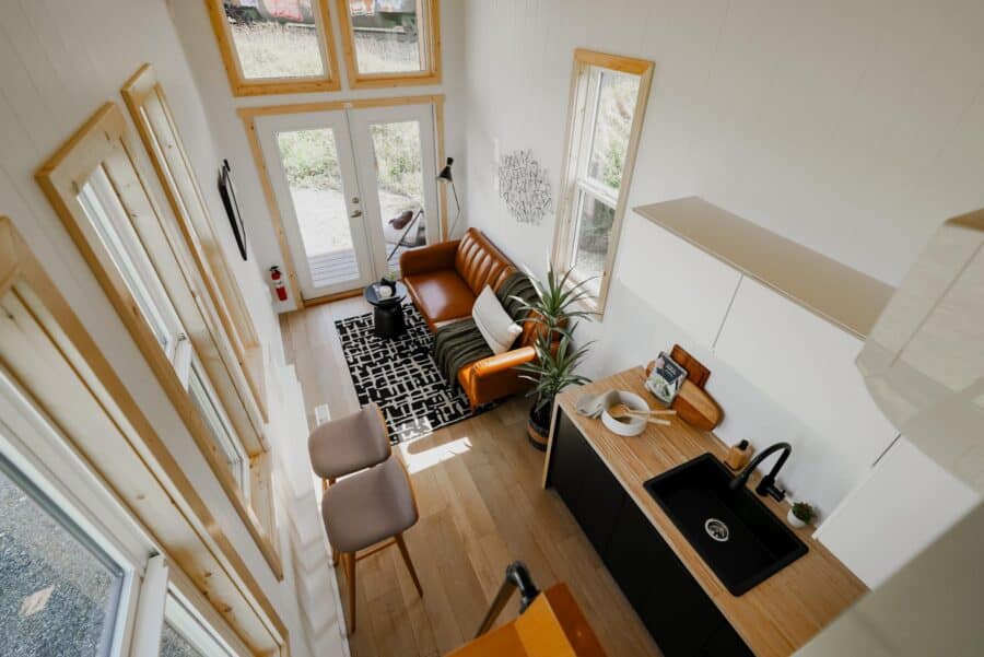 Bright tiny house interior with modern furniture and large windows.