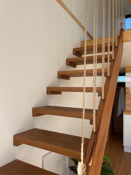 Wooden staircase with rope railing inside the Oslo tiny house by Little Byron.