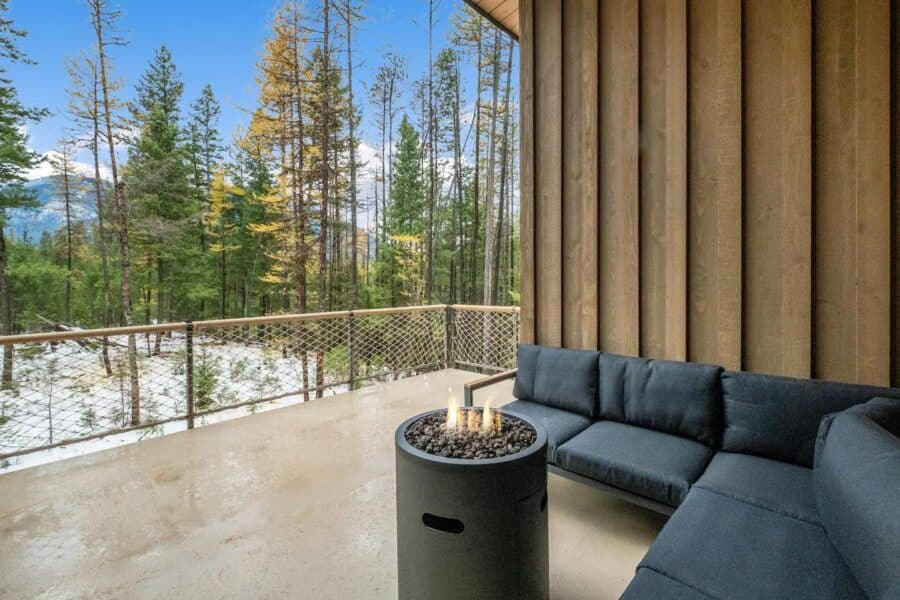 Secluded off-grid stilt cabin featuring a spacious balcony overlooking a lush forest landscape. Perf.