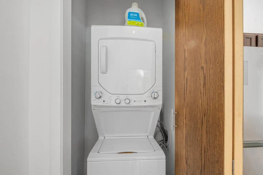Laundry space with stacked washer and dryer in a small, efficient cabin.