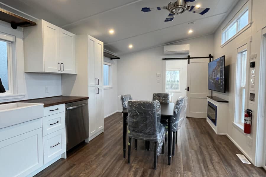 Bright interior of a tiny house with a modern kitchen and dining space.