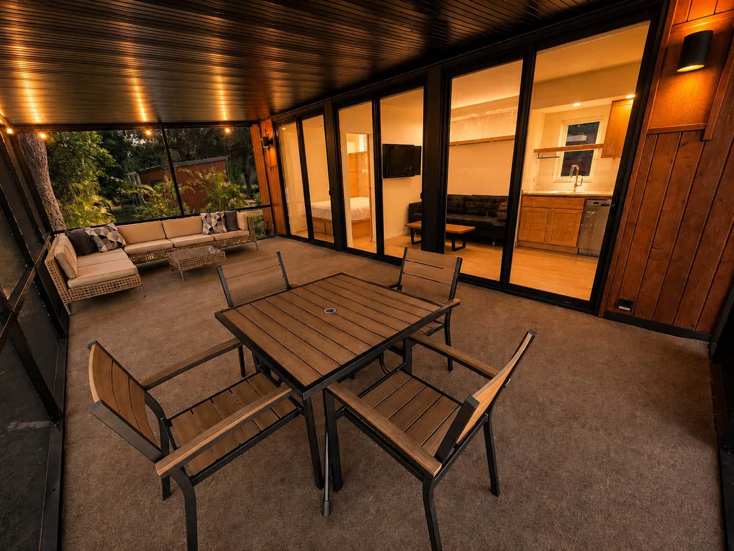 Screened Florida room with dining set and lounge seating on the Escape N2 at Palm Court Lot 28