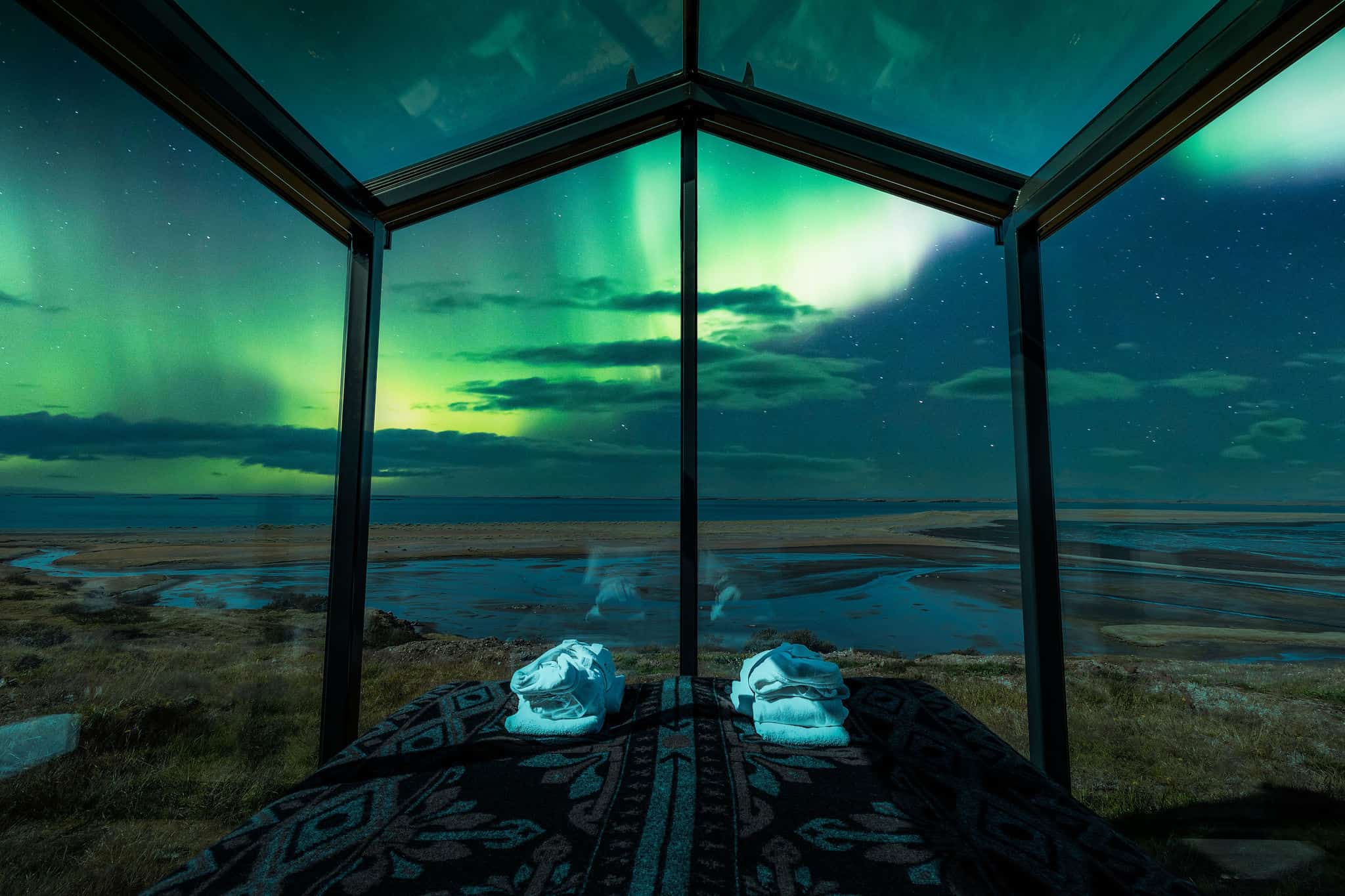 Northern lights seen from the bed of a Panorama Glass Lodge in Iceland
