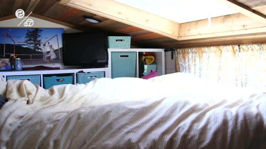 Sleeping loft under a large skylight with cubby storage inside a tiny house at Park Delta Bay