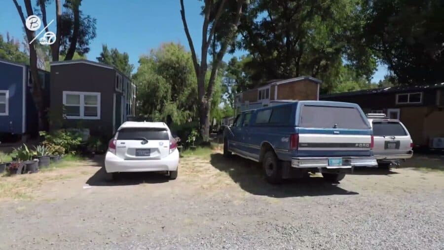 Row of tiny houses on wheels with parked cars along G Row at Park Delta Bay RV park in Isleton, California