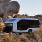 Electric tiny house on wheels in desert landscape.