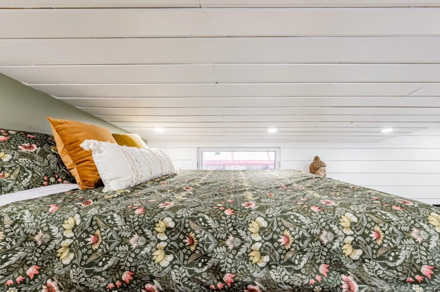 Compact pine needle tiny house interior with cozy sleeping area.