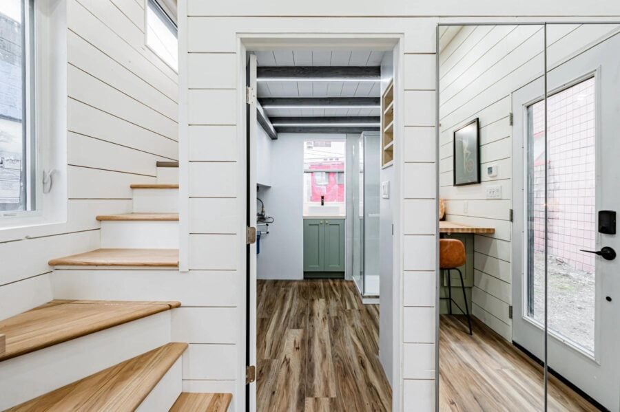 Charming tiny house interior with white shiplap walls and wooden accents.
