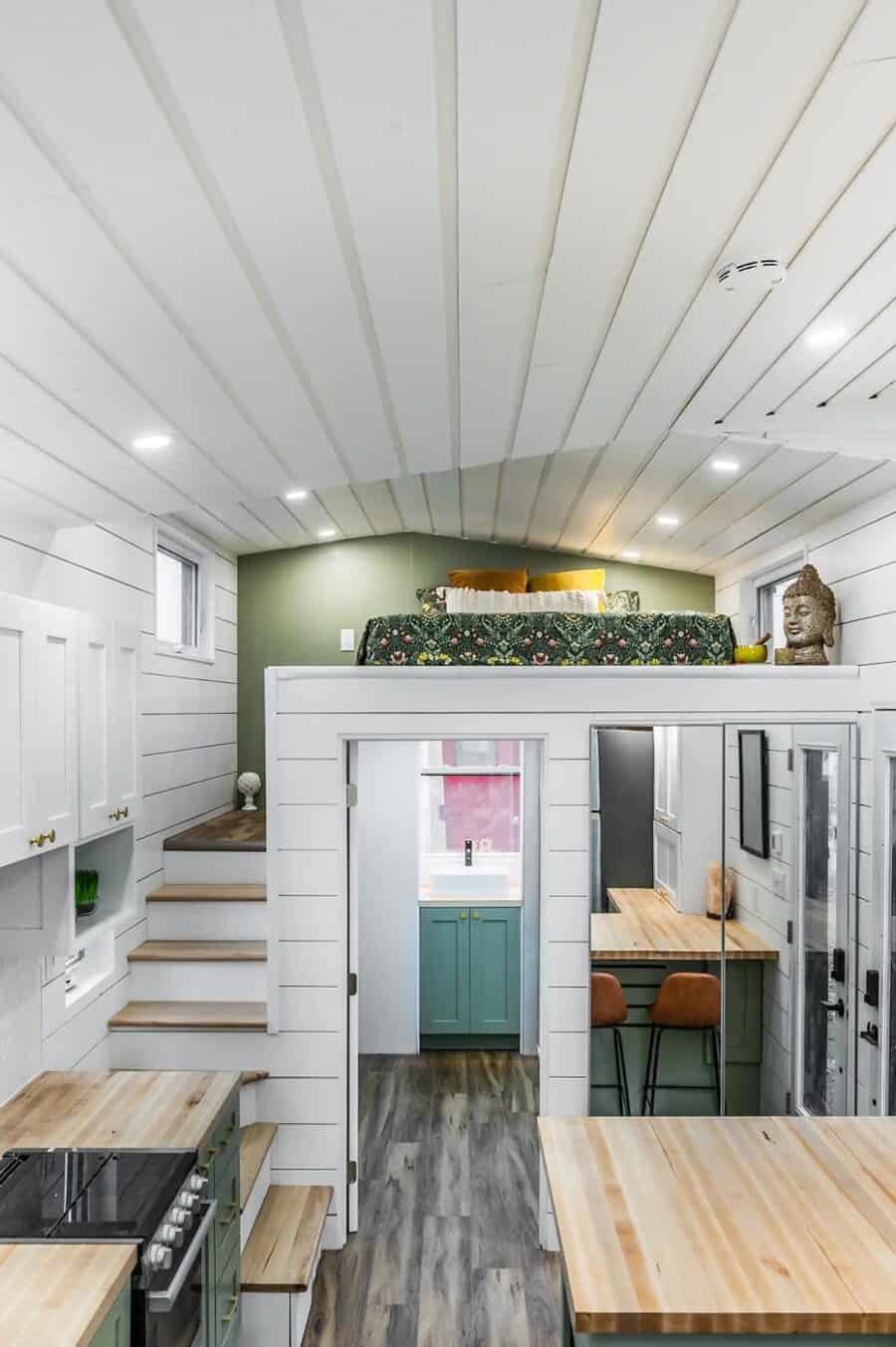 Cozy tiny house interior with loft sleeping area and modern kitchen design.